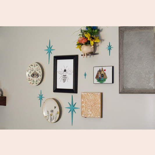 Atomic Age Wall Decor Stars hanging next to picture frames on a wall